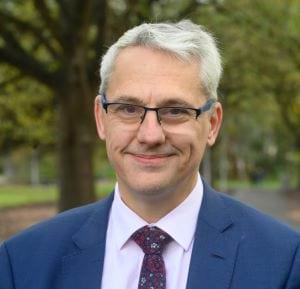 Headshot of Danny Pearson MP, standing in Treasury Gardens.